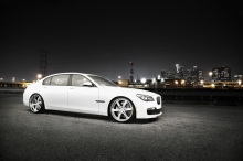 Белый BMW 7 series в свете фонаря под ночным небом